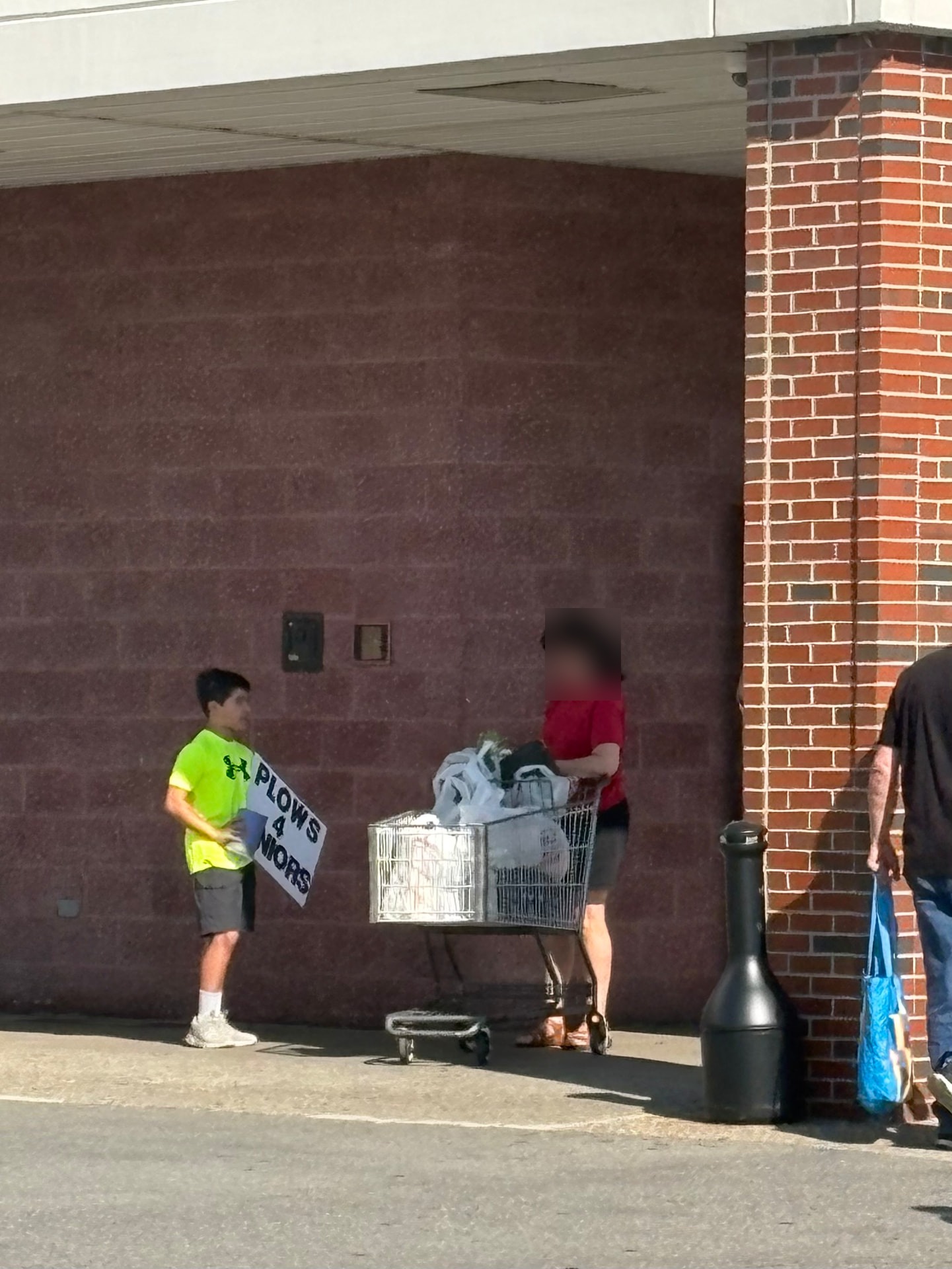 Young Plows4Seniors volunteer collecting donations from a shopper during Tag Day